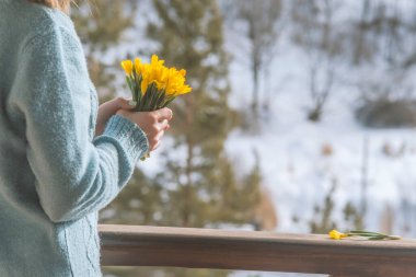 Bir buket sarı çiçeği tutan kadın