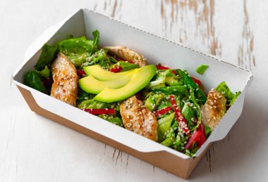 Paketinde avokado olan tavuk salatası. Sağlıklı öğle yemeği