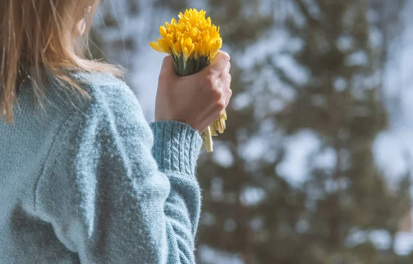 Bir buket sarı çiçeği tutan kadın