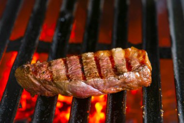 Alevli ızgarada ızgara biftekler seçici bir odak ile vurulacak.