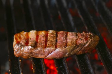 Alevli ızgarada ızgara biftekler seçici bir odak ile vurulacak.