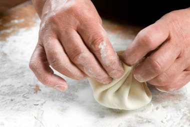 Aşçı ahşap masada khinkali yapıyor. İşlem hazırlığı Gürcistan yemeği. yiyecek konsepti.