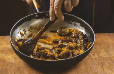 Aşçı eti sebzeli ve soğanlı bir kasede hazırlar. Doğu mutfağı.