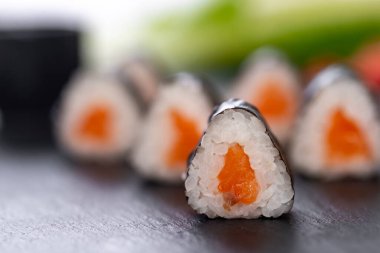 Bulanık arka planda somon balıklı suşi ruloları. 