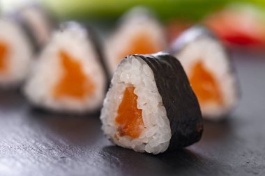 Bulanık arka planda somon balıklı suşi ruloları. 