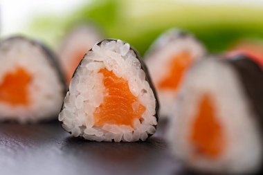 Bulanık arka planda somon balıklı suşi ruloları. 