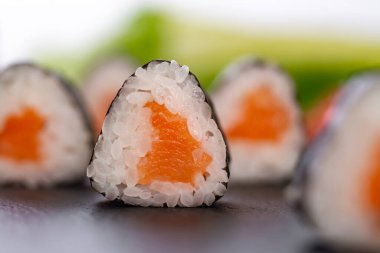Bulanık arka planda somon balıklı suşi ruloları. 
