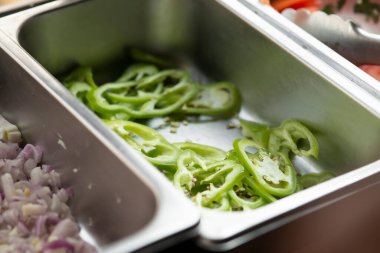 Sliced peppers in iron bowl, closeup