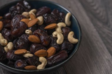 Karanlık bir arka planda fındıklar ve hurmalar.