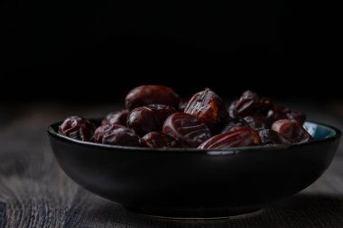 Karanlık bir arka planda fındıklar ve hurmalar.