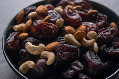 Karanlık bir arka planda fındıklar ve hurmalar.