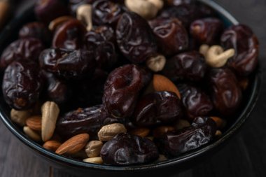 Karanlık bir arka planda fındıklar ve hurmalar.