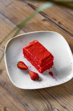 Red velvet cake with strawberries on a white plate