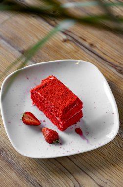 Red velvet cake with strawberries on a white plate
