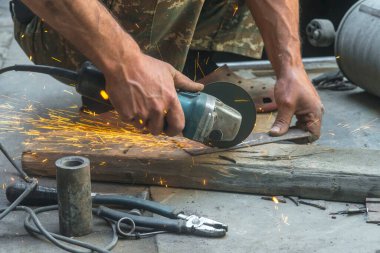 man welding electric steel with sparks and circular pipe