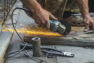 man welding electric steel with sparks and circular pipe