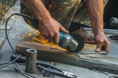 man welding electric steel with sparks and circular pipe