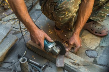 man welding electric steel with sparks and circular pipe