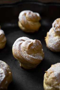 Close up shot of profiteroles with powdered sugar