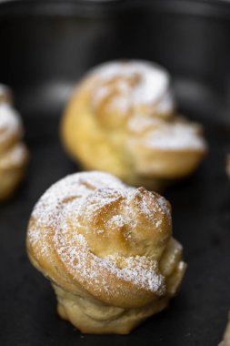 Close up shot of profiteroles with powdered sugar