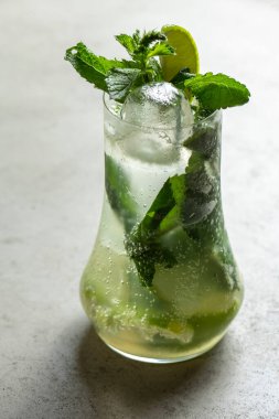 Mojito kireç ve highball cam gri taş zemin üzerine nane kokteyli .