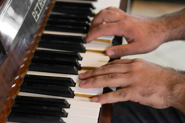 hands of a man playing piano .