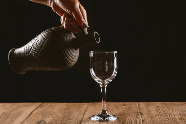 Flicka Hand Hälla Vin Glas Från Lera Flaska Svart Bakgrund — Stockfoto