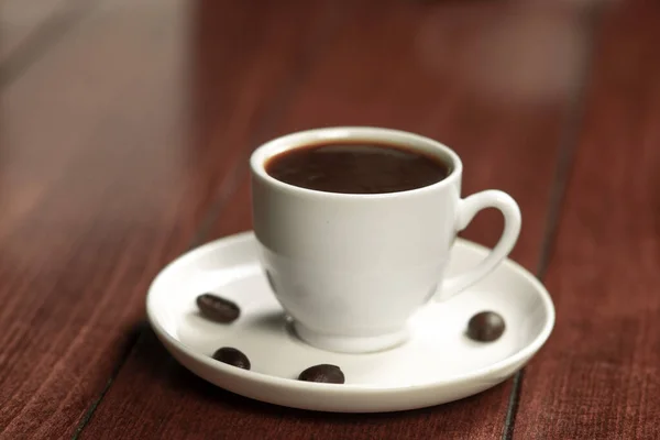 木製のテーブルの上にコーヒーカップとコーヒー豆 黒の背景 — ストック写真