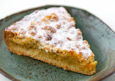 Beyaz ahşap masada seramik tabakta lezzetli bir turta.