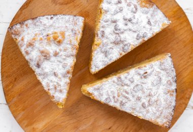 Beyaz arka planda, ahşap masada üç dilim turta..