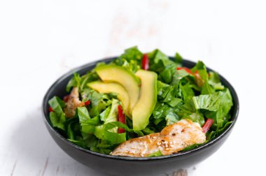 Siyah kasede avokadolu tavuk salatası. Sağlıklı yemek.
