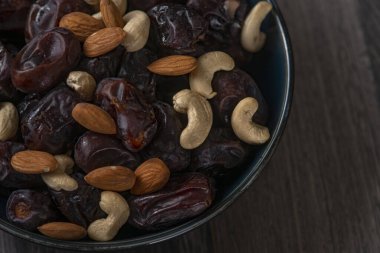 Karanlık bir arka planda fındıklar ve hurmalar.