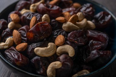 Karanlık bir arka planda fındıklar ve hurmalar.