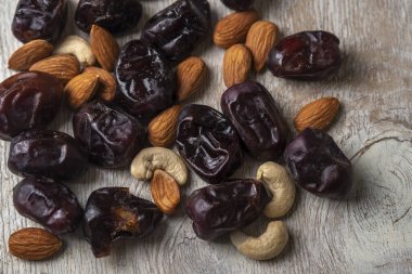 Gri ahşap arka planda hurmalar ve fındıklar