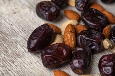 Gri ahşap arka planda hurmalar ve fındıklar