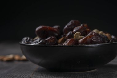 Karanlık bir arka planda fındıklar ve hurmalar.