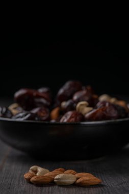 Karanlık bir arka planda fındıklar ve hurmalar.