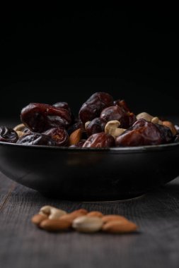 Karanlık bir arka planda fındıklar ve hurmalar.