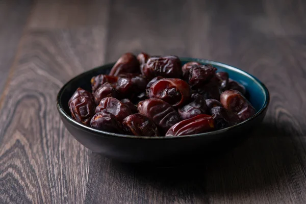 Karanlık bir arka planda fındıklar ve hurmalar.