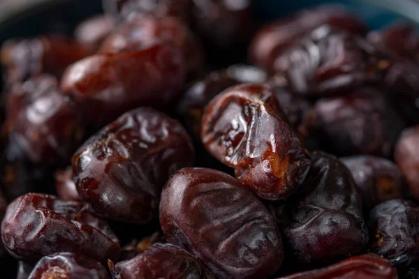 Karanlık bir arka planda fındıklar ve hurmalar.