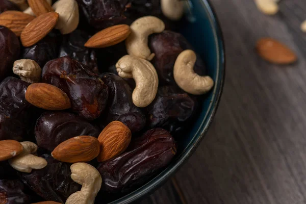 Karanlık bir arka planda fındıklar ve hurmalar.