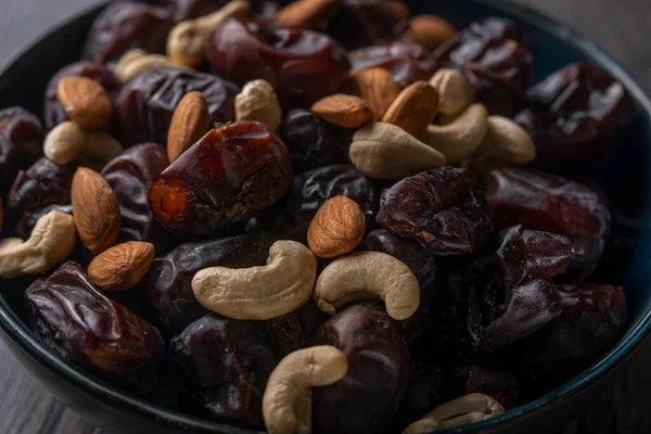 Karanlık bir arka planda fındıklar ve hurmalar.