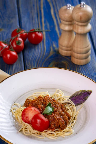 stock image italian Pasta bolognese with meat, tomato sauce and vegetables in blue wooden desk .