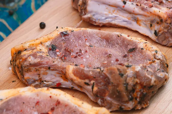 Rohes Schweinefleisch Und Zutaten Auf Einem Brett Auf Blauem Tisch — Stockfoto