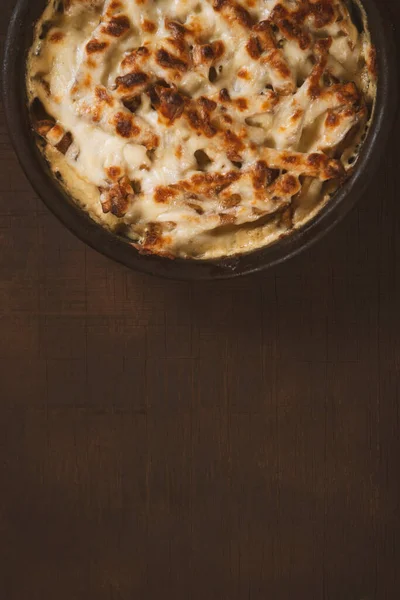진흙으로 과녹은 치즈로 뒤덮인 요리인 캐롤을 어두운 음식으로 대접하는 — 스톡 사진