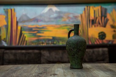 Tahta masada şarap bulunan antika bir amfora. .