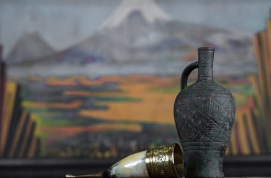 Tahta masada şarap bulunan antika bir amfora. .