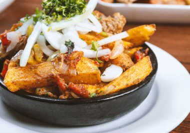 Beef stew with potatoes, carrots and herbs on black background with copy