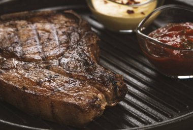 pork steak with vegetables in a black iron pan