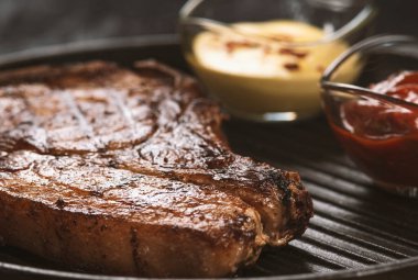 pork steak with vegetables in a black iron pan